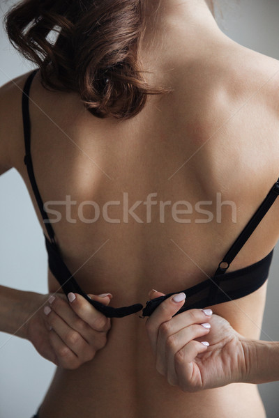 Back view of naked woman in bra Stock photo © deandrobot