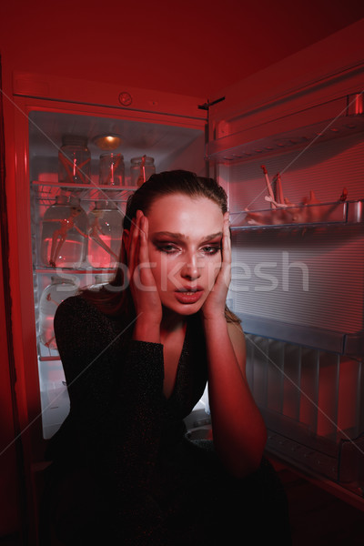 Vertical image of unusual woman sitting near fridge Stock photo © deandrobot