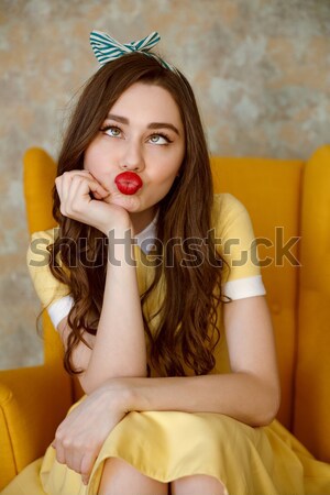 Vertical image of Uncomprehending woman sitting on armchair Stock photo © deandrobot