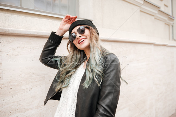 Lady wearing hat and sunglasses walking on the street. Stock photo © deandrobot