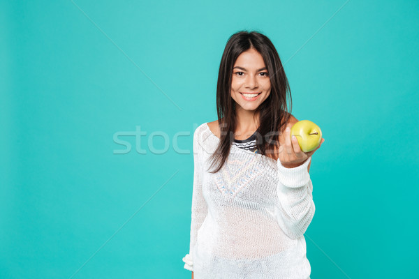 Happy friendly young woman standing and giving you fresh apple Stock photo © deandrobot