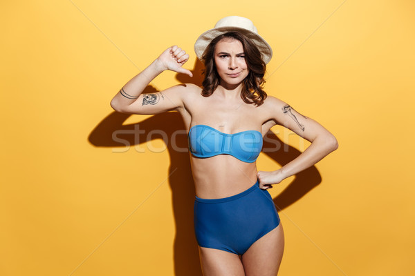 Sad young woman in swimwear showing thumbs down. Stock photo © deandrobot