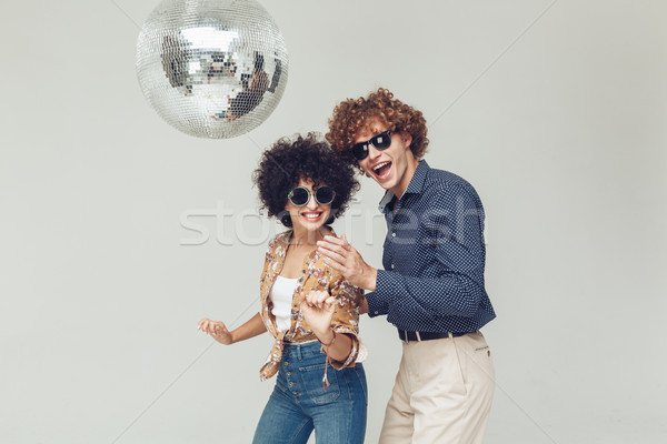 Emotional smiling retro loving couple dancing near disco ball. Stock photo © deandrobot