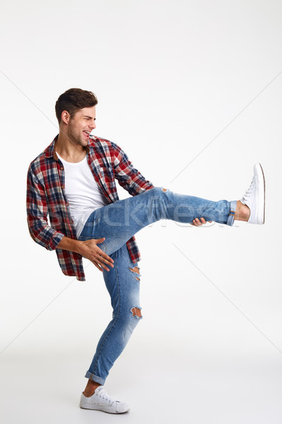 Portrait of a joyful young man pretending playing Stock photo © deandrobot