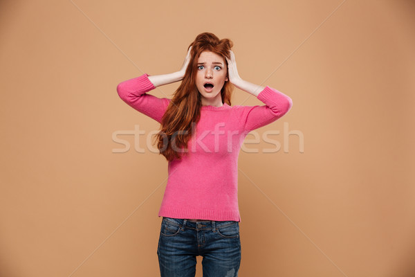Close up portrait of a shocked young redhead girl Stock photo © deandrobot