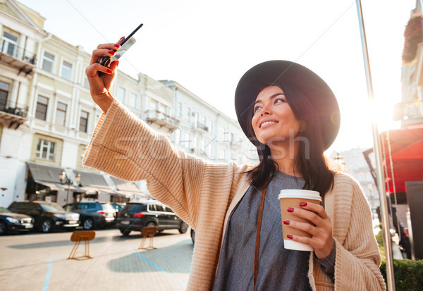 Portrait of a cheery pretty woman taking a selfie Stock photo © deandrobot