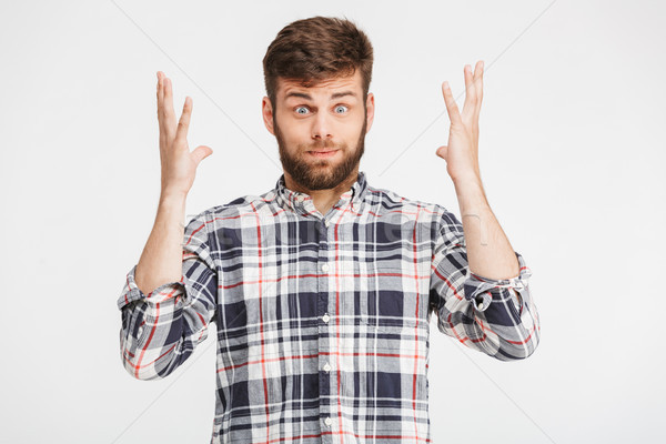 Portrait of a confused young man in plaid shirt Stock photo © deandrobot