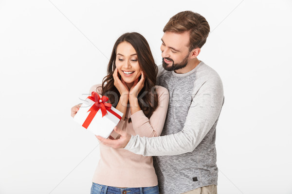 Excited young loving couple holding gift present box. Stock photo © deandrobot
