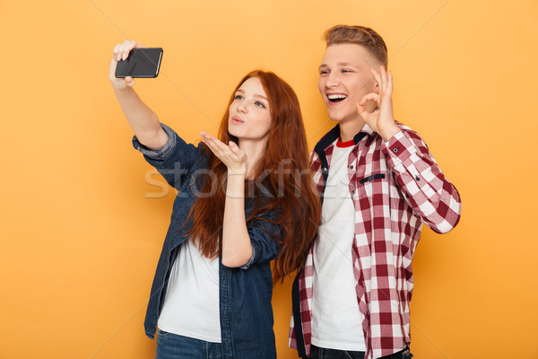 Portrait of a friendly teenage couple Stock photo © deandrobot