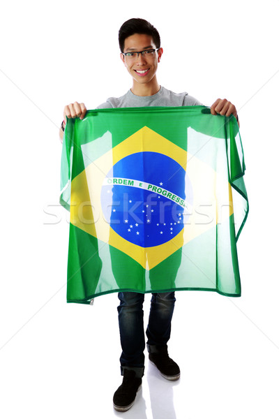 Stock photo: Portrait of a young asian man holding Brazilian flag over white background