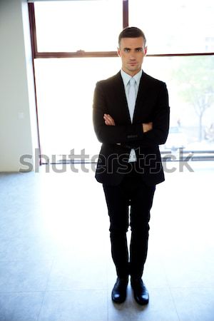 Full-length portrait of a confident businessman walking isolated on a white background Stock photo © deandrobot