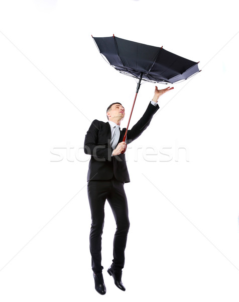 Businessman with umbrella fighting with strong wind over white background Stock photo © deandrobot