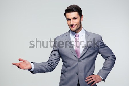 Businessman with arm out in a welcoming gesture Stock photo © deandrobot