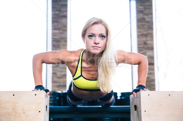 Stock photo: Beautiful sports woman doing push ups on fit box