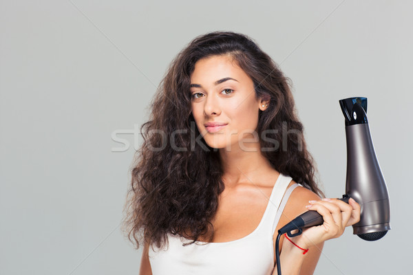 Cute attractive woman holding hairdrye Stock photo © deandrobot