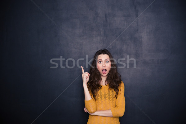 [[stock_photo]]: étonné · femme · pointant · doigt · up · noir