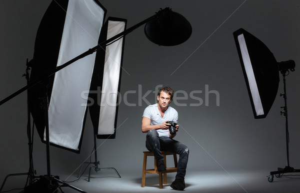 Man photograph sitting on the chair in professinal studio Stock photo © deandrobot