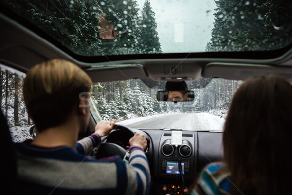 Stock photo: Beautiful couple driving in car through winter forest