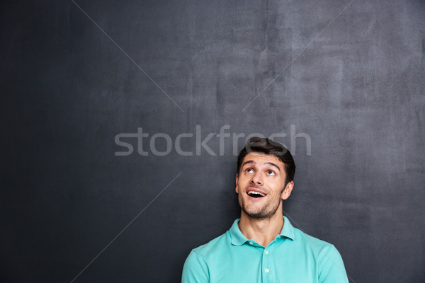 Boldog fiatalember száj kinyitott felfelé néz iskolatábla Stock fotó © deandrobot