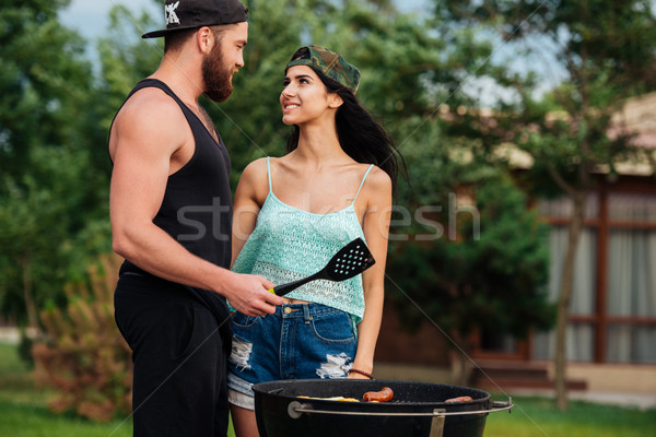 Couple standing and frying on barbeque grill outdoors Stock photo © deandrobot