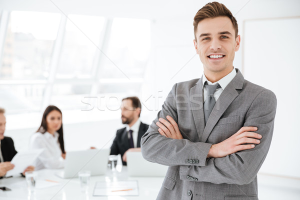 Smiling Business man with colleagues on background Stock photo © deandrobot