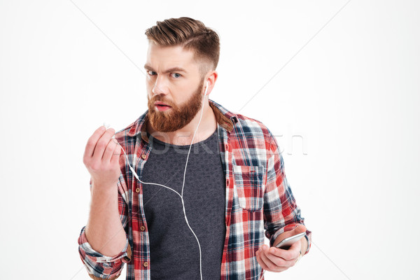 Infelice irritato giovane ascoltare musica smartphone bianco Foto d'archivio © deandrobot