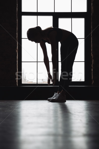 Silhouette of fitness woman stretching near the window Stock photo © deandrobot