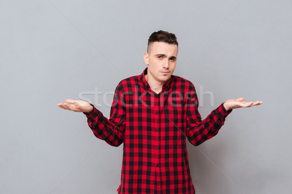 Young displeased man in shirt Stock photo © deandrobot