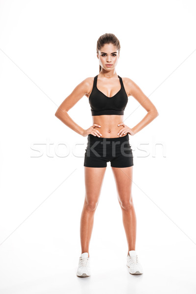 Full length of fitness woman standing with hands on waist Stock photo © deandrobot