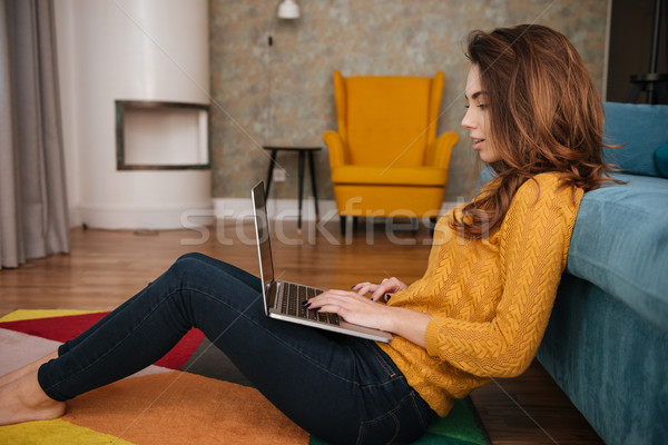 Side view of a young cute girl working on laptop Stock photo © deandrobot
