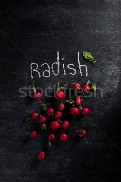 Radish over dark chalkboard background Stock photo © deandrobot