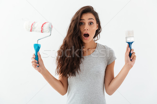 Amazed shocked young woman holding brush and paint roller Stock photo © deandrobot