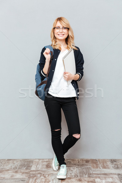 Happy young lady student holding notebook. Stock photo © deandrobot