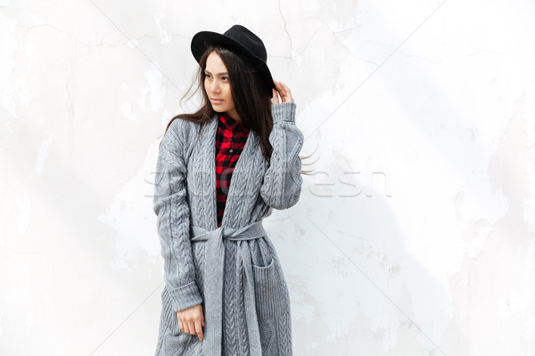 Stock photo: Young woman wearing hat standing in the street and looking away