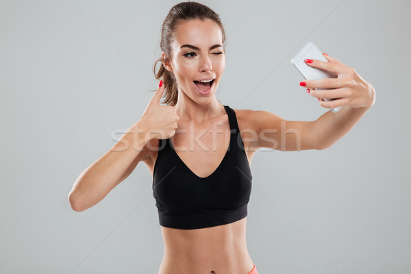 Happy fitness woman making selfie on her smartphone Stock photo © deandrobot