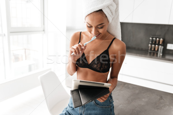 Smiling asian woman with bath towel wrapped around her head Stock photo © deandrobot