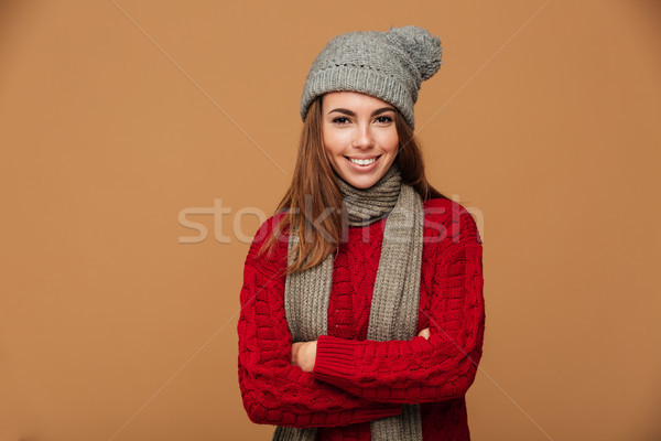 Cheerful young brunette woman in knitted wear standing with cros Stock photo © deandrobot