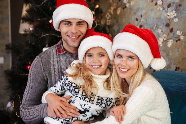 Close-up portrait of happy young family in Santa's hat looking a Stock photo © deandrobot