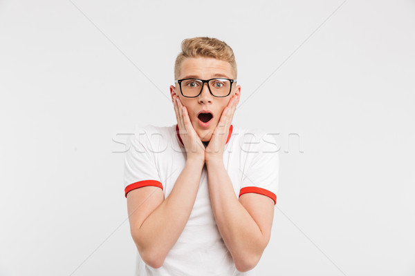 Photo of surprised guy in eyeglasses screaming and grabbing face Stock photo © deandrobot