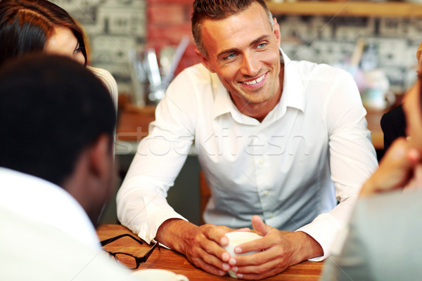 Happy business people having meeting around table in office Stock photo © deandrobot