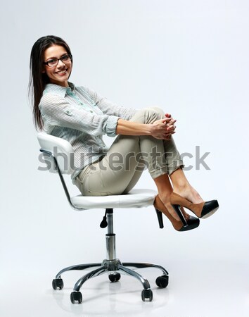 Güzel bir kadın oturma sandalye gri ofis Stok fotoğraf © deandrobot