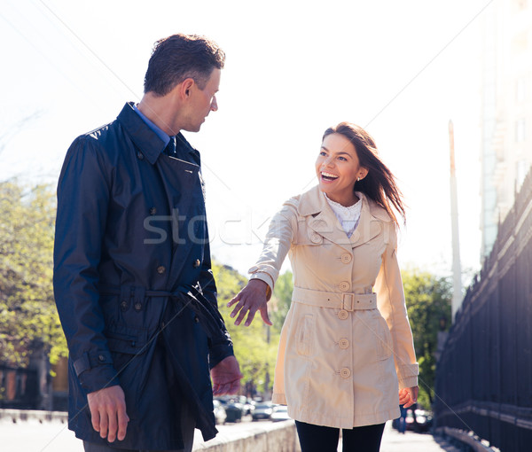 Happy woman inviting man outdoors Stock photo © deandrobot