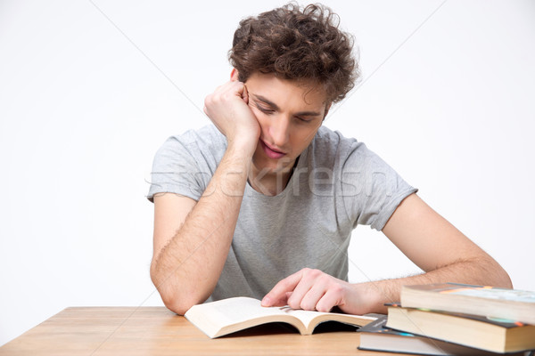 Stock photo: Tired male student sitting at the table with books