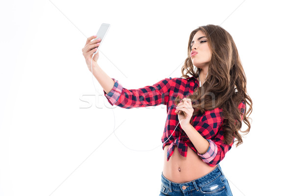 Cute lovely young woman making duck face and taking selfie  Stock photo © deandrobot
