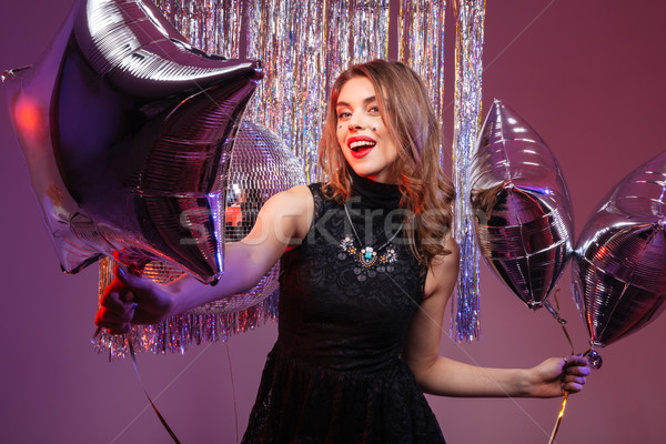 Cheerful beautiful woman holding star shaped balloons  Stock photo © deandrobot