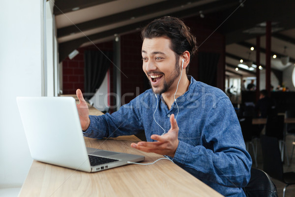 Stock photo: Man video chatting on laptop computer in office