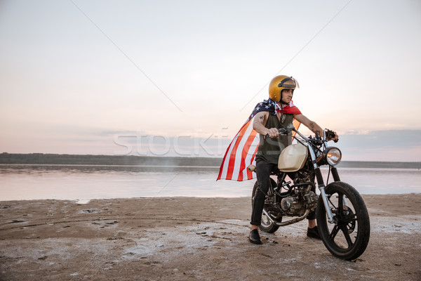 Stock photo: Man in golden helmet and american flag cape driving motorcycle