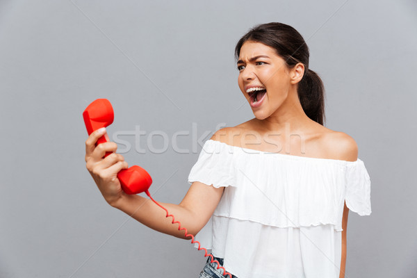 Enojado mujer gritando teléfono tubo morena Foto stock © deandrobot