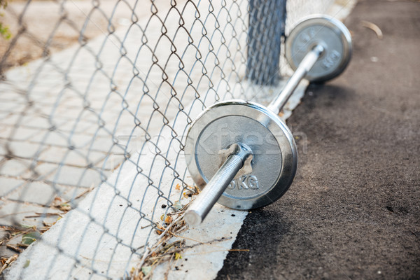 Dumbbells with weights lying on sports ground Stock photo © deandrobot
