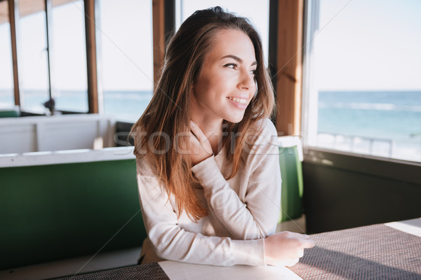 Smiling Woman in cafe near the sea Stock photo © deandrobot